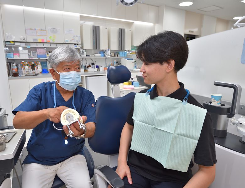 歯の模型で説明する院長と患者